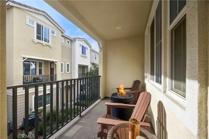 Private covered second-level balcony with firepit seating, perfect for morning coffee or evening vibes.