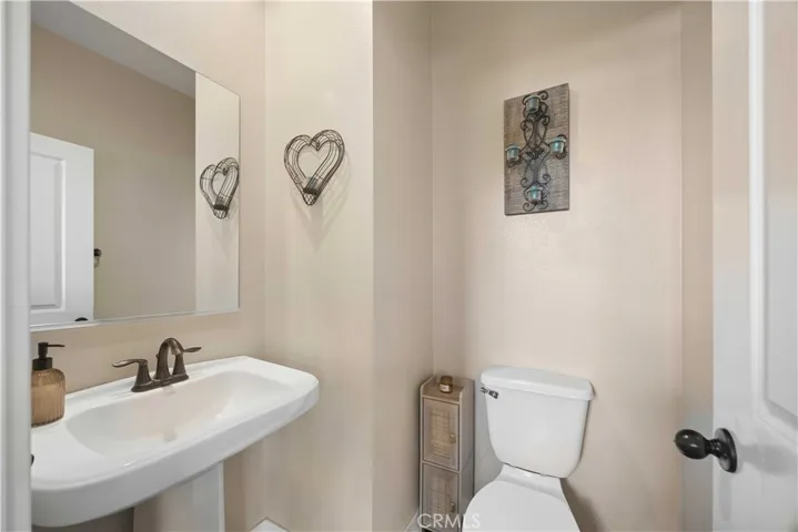 Convenient main-level powder room with pedestal sink & matte black fixtures.