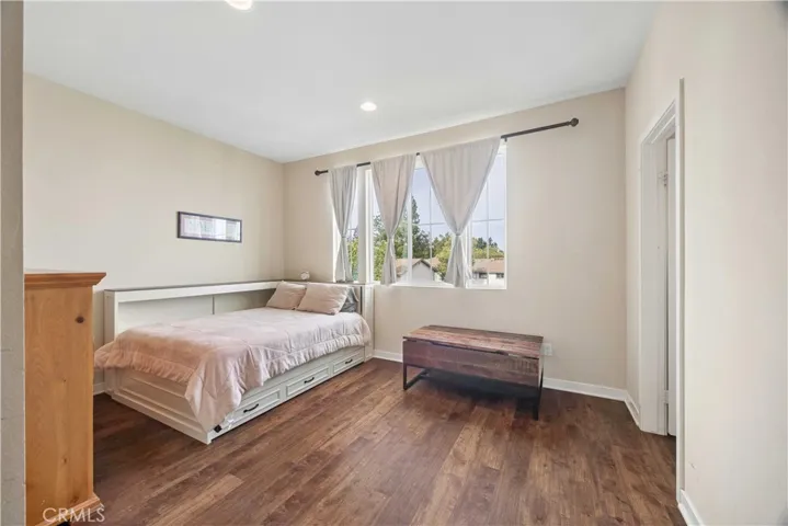 Bright third-level secondary bedroom with hardwood floors, natural light, and en-suite bath.