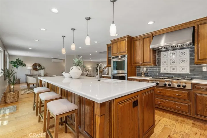 Quartz island has a utility sink and storage...custom tile backsplash and quartz countertops...