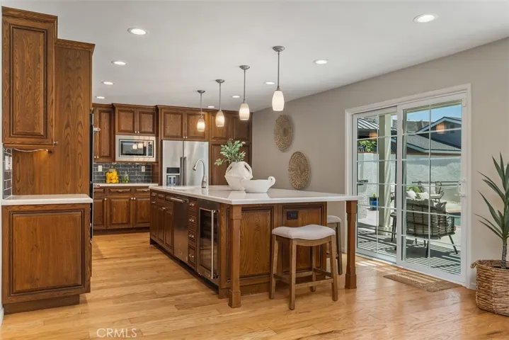 Remodeled Kitchen with large quartz island and seating, wine refrigerator