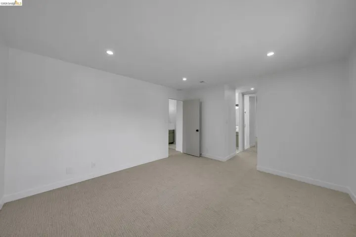 Expansive room featuring recessed lighting, light-toned carpet flooring, white walls, and white trim