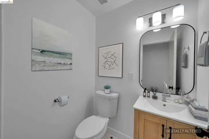 Bathroom featuring a vanity with a white countertop, an undermount sink, and a wood-finish cabinet with woven paneling