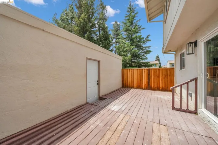 Outdoor deck space featuring wood-finish decking and a wooden privacy fence