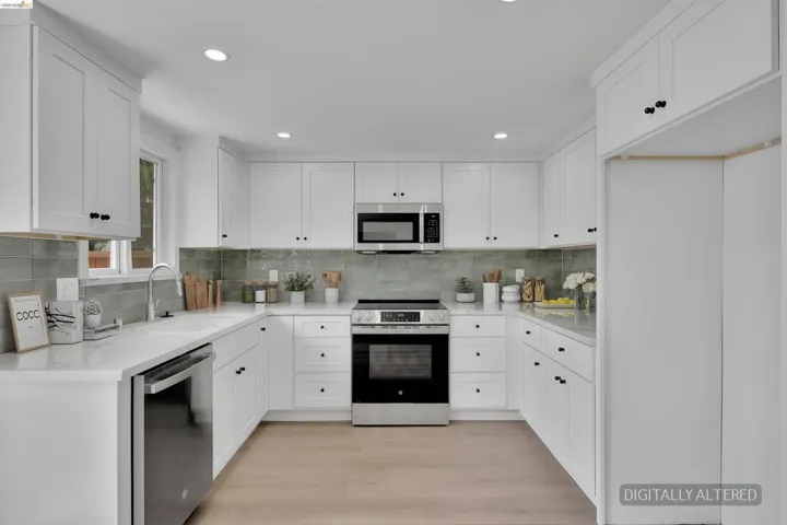 U-shaped kitchen featuring white shaker cabinetry, stainless steel appliances, a light-toned tile backsplash, recessed lighting, and wood-finish flooring