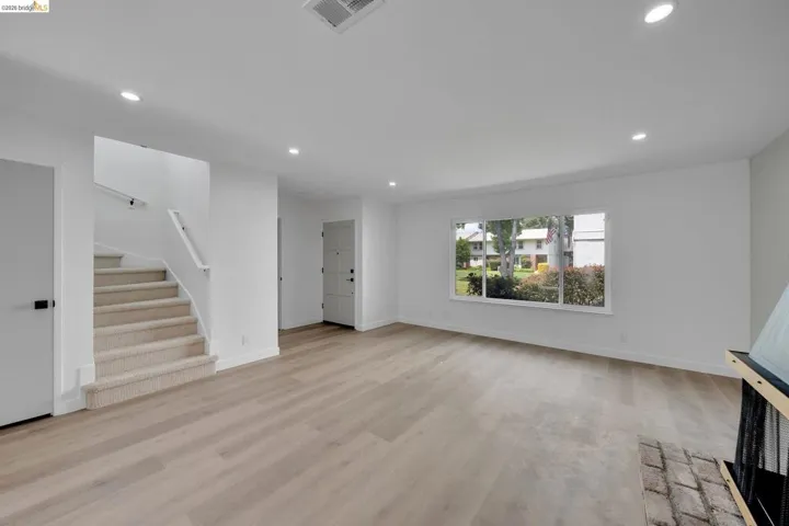 Spacious interior featuring light wood-finish flooring, recessed lighting, and white walls