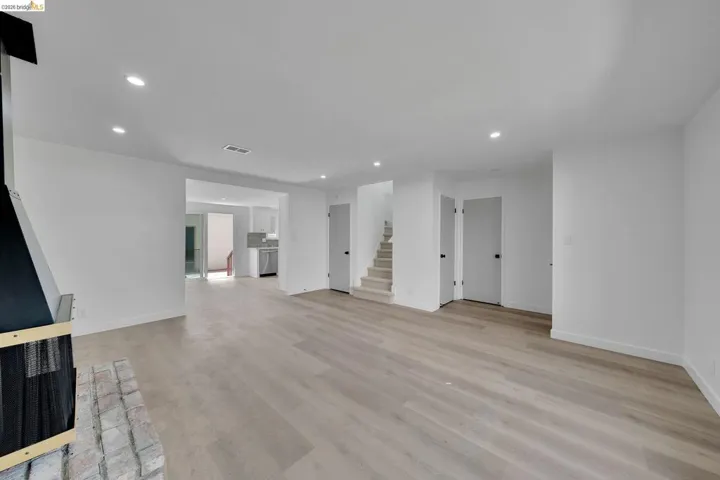 Spacious room featuring light wood-finish flooring, recessed lighting, and white baseboards