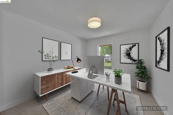 Light gray walls with a single window, overhead flush-mount lighting, and carpet flooring