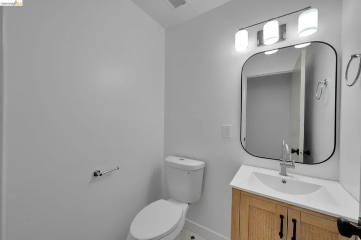 Modern vanity featuring wood-finish cabinetry, integrated sink, and matte black hardware