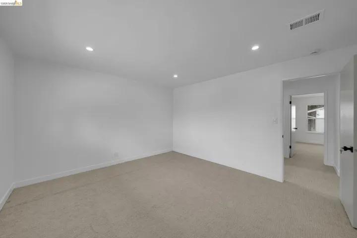 Carpeted interior space with white walls and recessed ceiling lighting