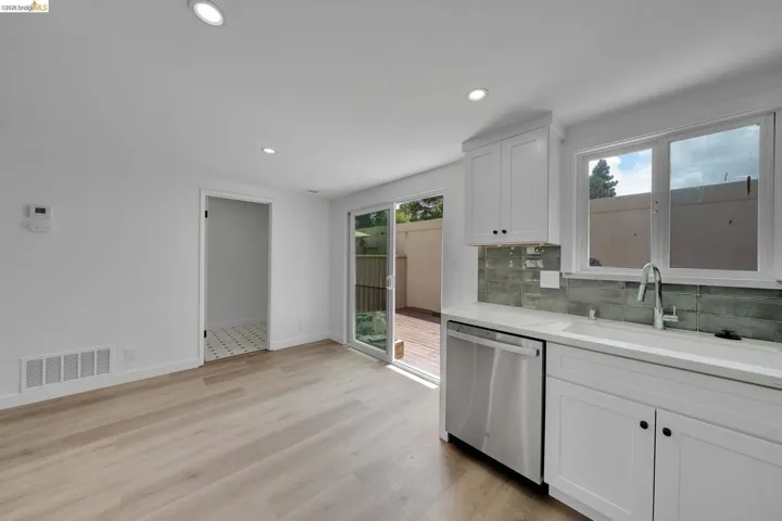 Contemporary kitchen featuring white cabinetry, light-toned countertops, and a subway tile backsplash