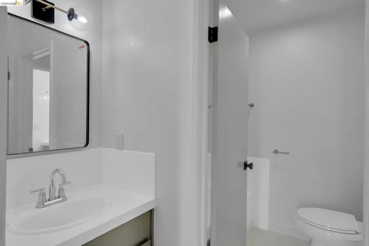 Bathroom vanity with an integrated sink, polished chrome faucet, and a contemporary mirror with a black frame