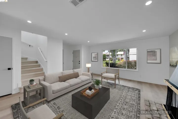 Bright living area featuring wood-finish flooring, recessed lighting, and a prominent window