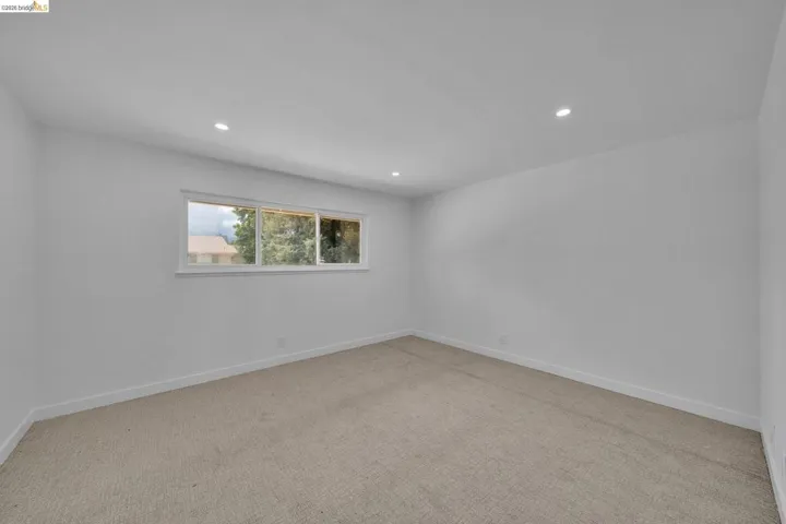 Neutral-toned carpeting paired with white baseboards and walls