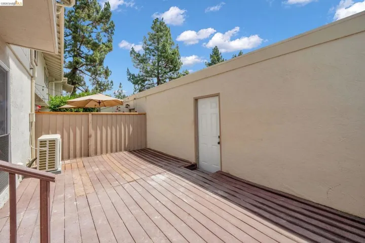 Expansive outdoor wood deck with perimeter fencing and an exterior entry door