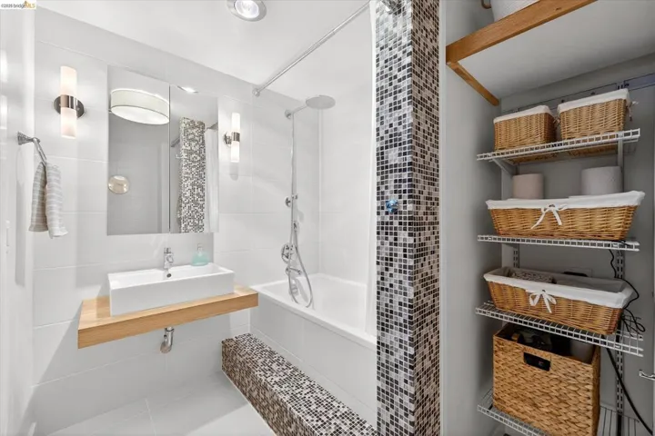 Contemporary bathroom featuring a floating wood-finish vanity with a rectangular vessel sink, a tub/shower combination, mosaic tile accents, and recessed overhead lighting