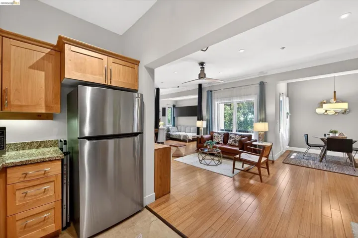 Stainless steel refrigerator complemented by light wood cabinetry and granite-style countertops