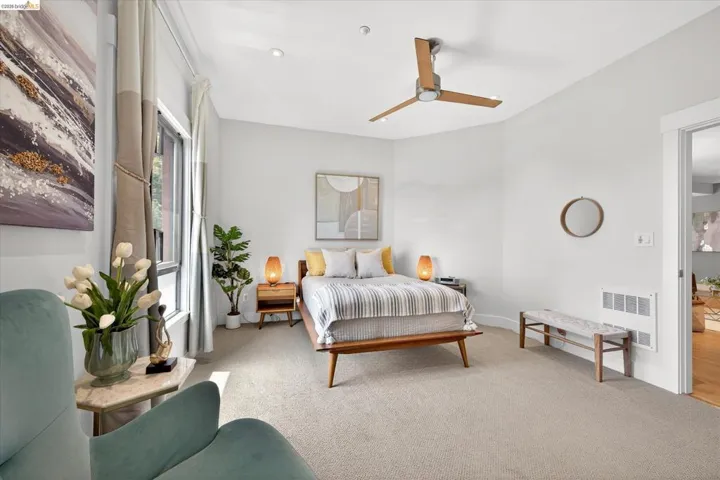 Carpeted room featuring a ceiling fan with wood-finish blades, recessed lighting, and a large window with vertical blinds