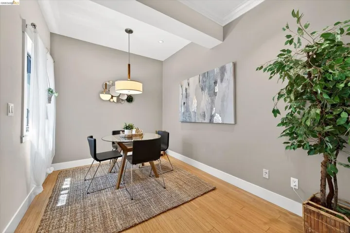 Dining area featuring light wood-finish flooring, neutral-toned walls, and white crown molding
