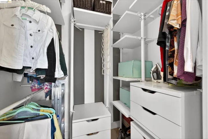 Custom closet system featuring multiple hanging rods, adjustable shelving, and integrated drawer units