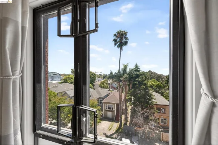 Black-framed casement windows with white privacy curtains