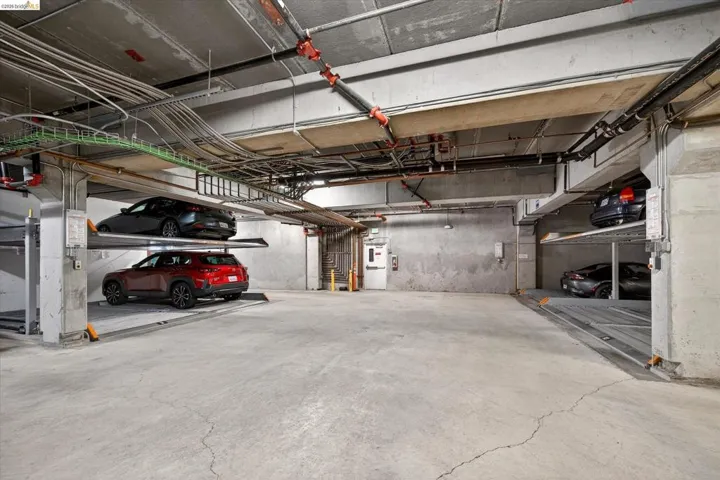 Dedicated parking garage featuring concrete flooring and exposed overhead utilities