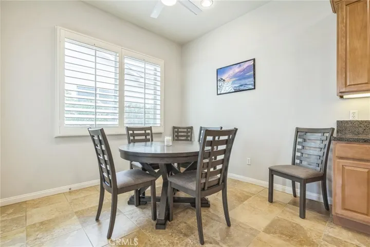 The kitchen dining area has a ceiling fan and lots of light through the plantation shutters.