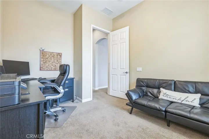 The den is being used by the homeowner as an office and the sofa folds into a bed for extra company. There's a ceiling fan to circulate the air to save on cooling costs.

