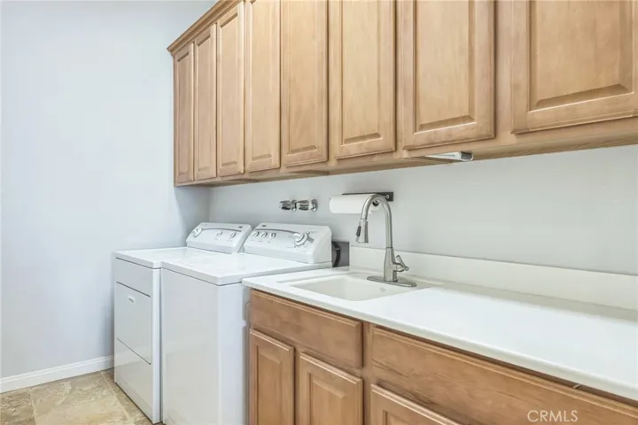 The laundry room is very spacious. There's a laundry sink, folding area and lots of cabinets to store all your laundry supplies.