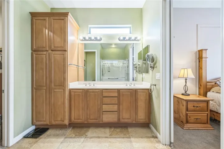 Pretty vanity with dual sinks and a large linen storage cabinet.