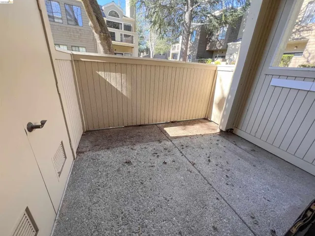 Private outdoor patio with composite fencing and exposed aggregate concrete flooring