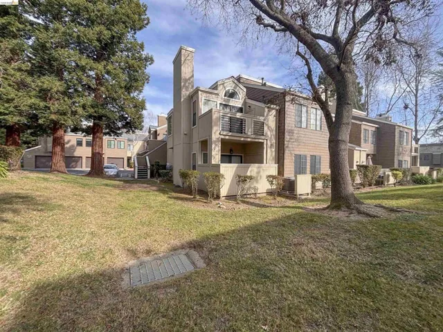 Multi-level residential building featuring a prominent chimney, upper-level balcony, and varied exterior siding