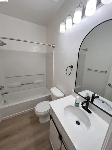 Bathroom with a white vanity featuring a rectangular integrated sink and matte black faucet