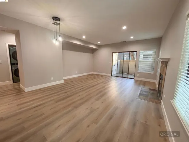 Spacious living area featuring wood-finish flooring, recessed lighting, and a modern chandelier