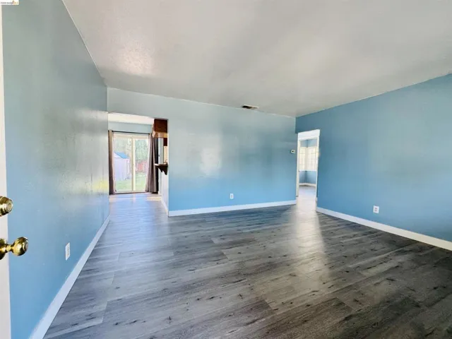 Spacious interior featuring wood-finish flooring, light blue wall finishes, and white trim