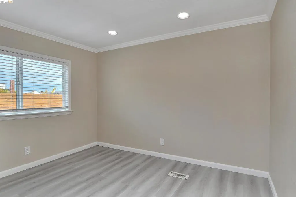Spare room with ornamental molding, light wood-type flooring, and recessed lighting