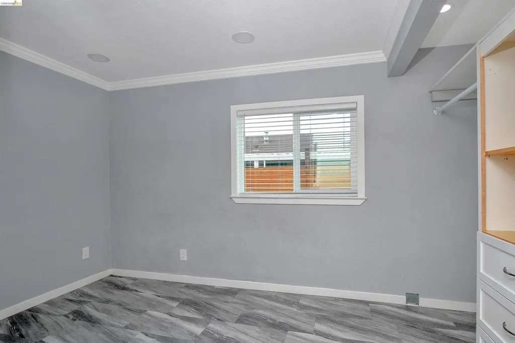 Unfurnished room with ornamental molding and baseboards
