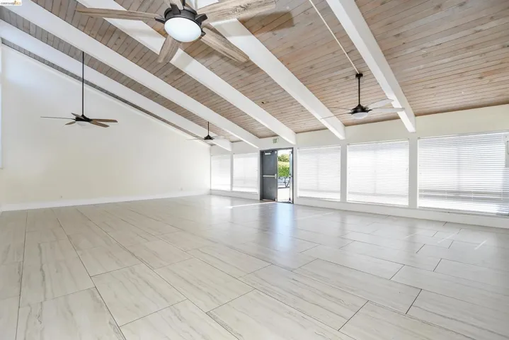Unfurnished living room featuring high vaulted ceiling and a wooden ceiling with exposed beams
