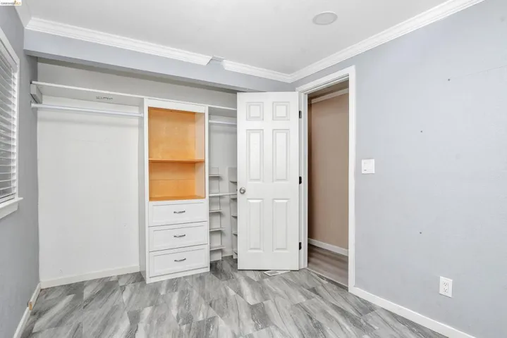 Unfurnished bedroom featuring ornamental molding and a closet