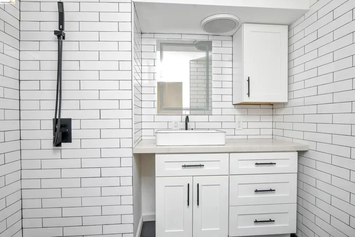 Bathroom featuring vanity and tile walls