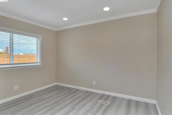 Spare room with ornamental molding, light wood-type flooring, and recessed lighting