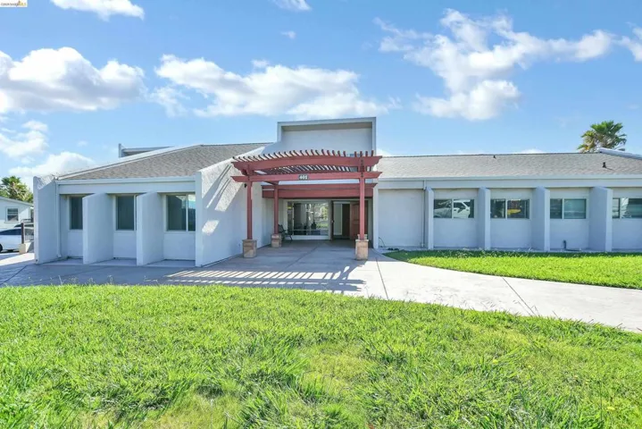 Back of property with a yard, a pergola, stucco siding, and roof with shingles
