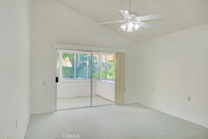 Right-side primary bedroom has a vaulted ceiling and direct access to the enclosed rear patio.