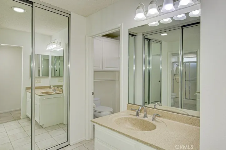 Right-side bathroom has closets with mirrored doors.