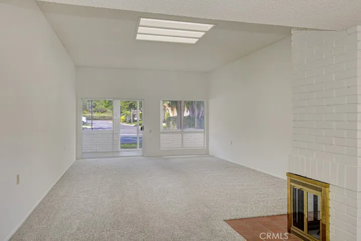 Spacious living room features a high ceiling, skylights and a wood-burning courtyard.