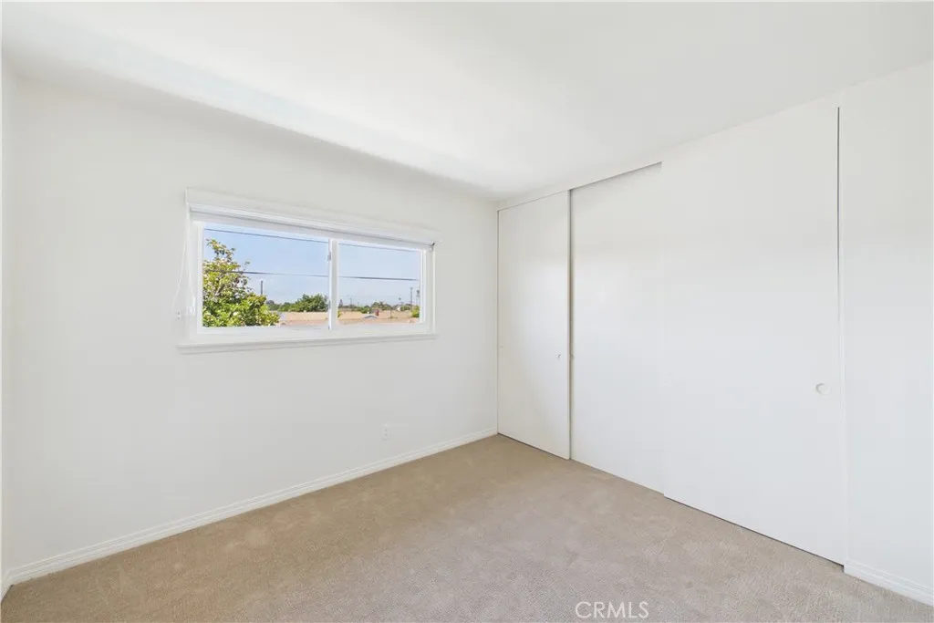 This bedroom is the easternmost of the 3 additional bedrooms with a view of pool and backyard