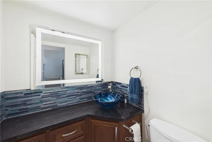 Powder bath with a lit mirror and Toto toilet