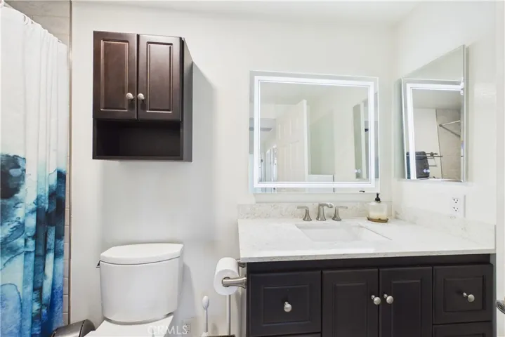 Remodeled upstairs hall bath with a lit mirror and plenty of storage