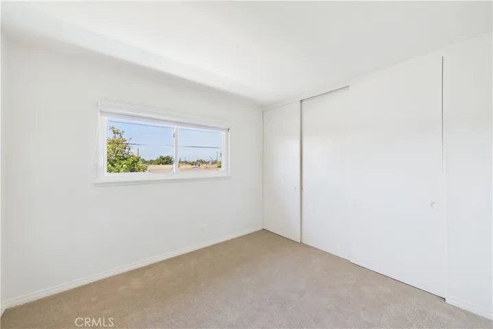 This bedroom is the easternmost of the 3 additional bedrooms with a view of pool and backyard