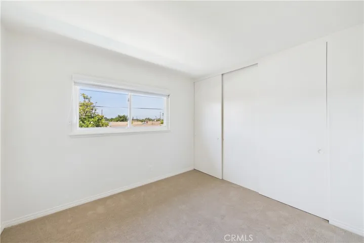 This bedroom is the easternmost of the 3 additional bedrooms with a view of pool and backyard
